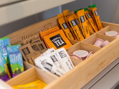 A wooden box containing tea bags coffee sachets and coffee pods at Verity in Mullion