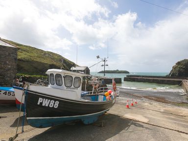 A boat docked by a pier near the water at Daphne in Mullion