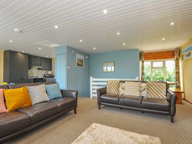 A living room with sofas and kitchen area at 37 Tamar St Ann's Chapel near Callington