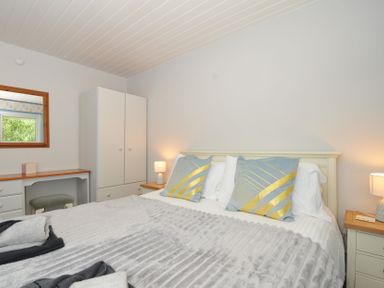 A bedroom with a bed and mirror at 37 Tamar, St Ann's Chapel near Callington