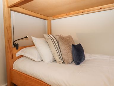 A wooden bunk bed with white bedding and four pillows in a bedroom at Hole Farm Stables Bickington near Ashburton