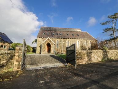 A stone building with a gravel driveway at Church Llygad Y Dyffryn in Sarnau near Brynhoffnant