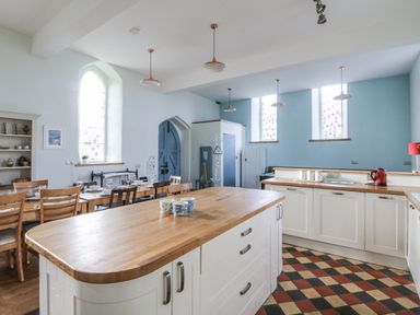 A kitchen with a dining table and kitchen island at Church Llygad Y Dyffryn Sarnau near Brynhoffnant