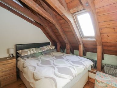 A bedroom with a bed and nightstand at Church Llygad Y Dyffryn Sarnau near Brynhoffnant