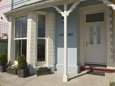 Front entrance with bay window flower pots and a door at Leylands in Salcombe