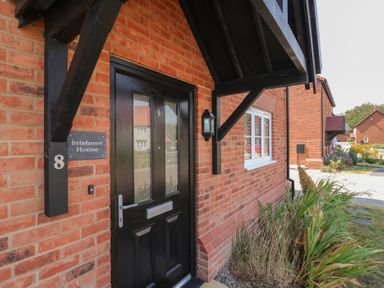 An entrance with a black door and nameplate at Inishnee House in Shotley Gate