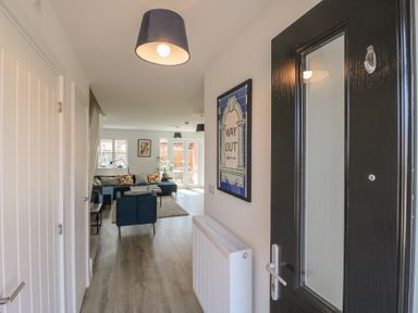 A hallway with a door and a view into a living area at Inishnee House in Shotley Gate