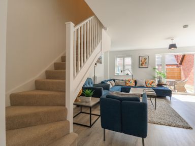 A living room with a staircase and a sofa at Inishnee House in Shotley Gate
