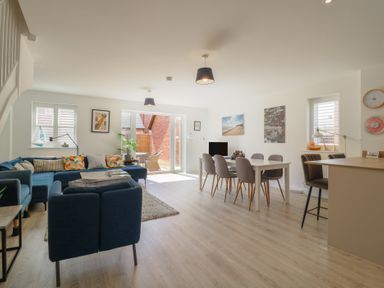 A living room with a sofa and dining area at Inishnee House in Shotley Gate