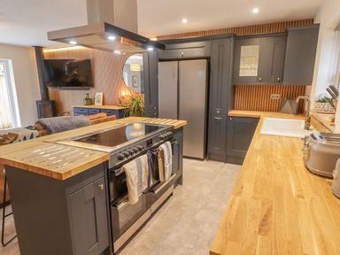 A kitchen with wooden countertops stove and fridge at The Grove in Wolfsdale near Haverfordwest
