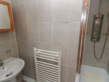A bathroom with a sink and shower at Horseshoe Cottage Near Holywell Bay