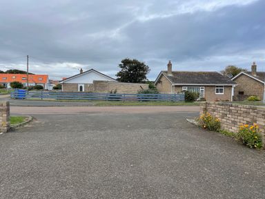 A residential street with single-story houses and a paved driveway at Villa Rose in Beadnell near Seahouses