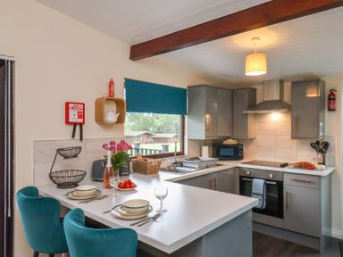 A kitchen with gray cabinets and a countertop set for two with bowls glasses and silverware at Ramson in Saltburn-By-The-Sea