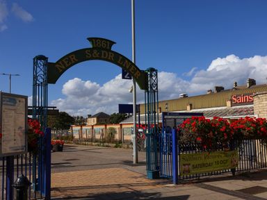 An entrance arch and shopping center with flowers at Ramson in Saltburn-By-The-Sea