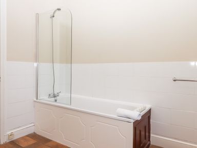 A bathroom with a bathtub shower combination and a towel on the tub edge at Alston Hall in Battisborough Cross