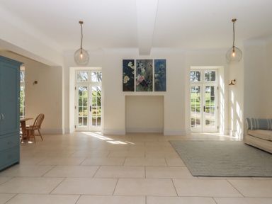 A living room with a dining table and sofa at Alston Hall near Mothecombe Beach