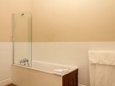 A bathroom with a bathtub and a towel at Alston Hall near Mothecombe Beach