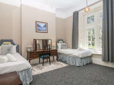 A bedroom with two beds and a desk at Alston Hall near Mothecombe Beach