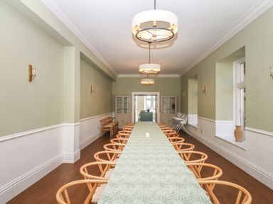 A dining room with a long table and chairs at Alston Hall near Mothecombe Beach