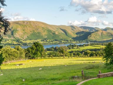 A landscape view featuring mountains, a lake, and sheep at Bank Barn, Wreay Watermillock