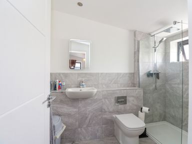 A bathroom with a sink mirror toilet shower and personal care items at 6 Strathtay Lodges in Aberfeldy
