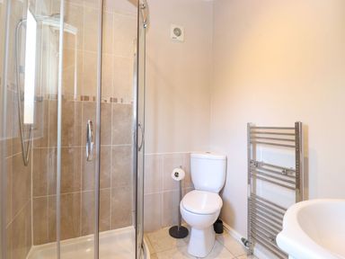A bathroom with a shower enclosure toilet towel rail and sink at Brightwater Lodge White Cross Bay near Windermere