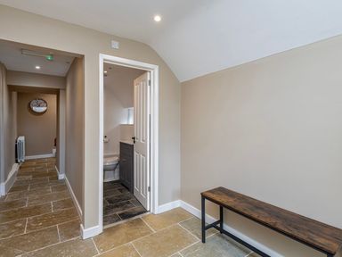 A hallway with a clock and a toilet at Snowdonia Manor in Dolgellau