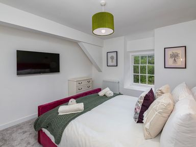 A bedroom with a bed and television at Snowdonia Manor in Dolgellau