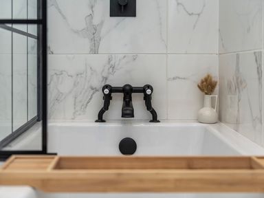A bathroom with a bathtub and a faucet at Snowdonia Manor in Dolgellau