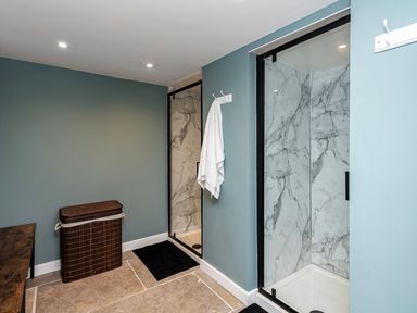 A bathroom with a shower and laundry basket at Snowdonia Manor in Dolgellau