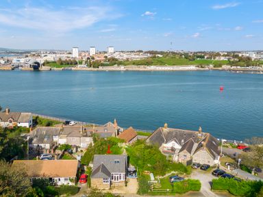 A riverside village with houses near water and a town across the river at Seascape in Kingsand