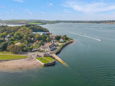 A coastal village with buildings trees boats and a beach at Seascape in Kingsand