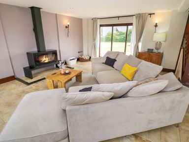 A living room with a fireplace sofa and coffee table at Little Acre Church Lench near Harvington