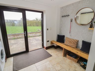 An entrance area with a bench and coat hooks at Little Acre Church Lench near Harvington