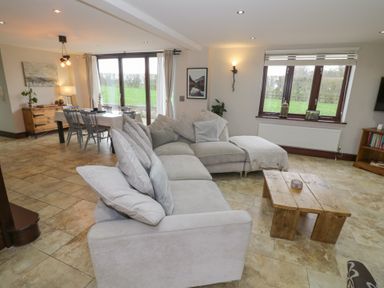 A living room with a sofa and coffee table at Little Acre in Church Lench near Harvington