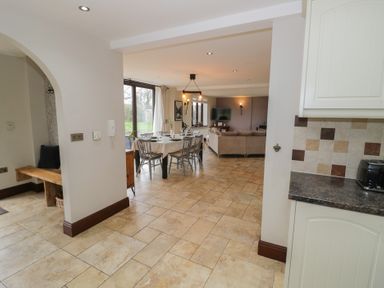 A kitchen and dining area with a sofa and television at Little Acre, Church Lench near Harvington
