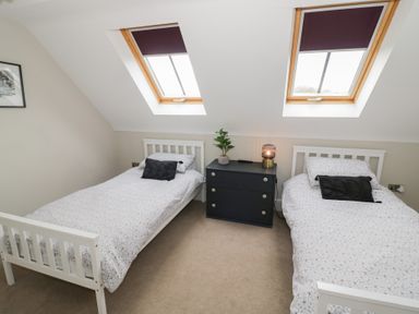 A bedroom with two single beds and a nightstand at Little Acre Church Lench near Harvington