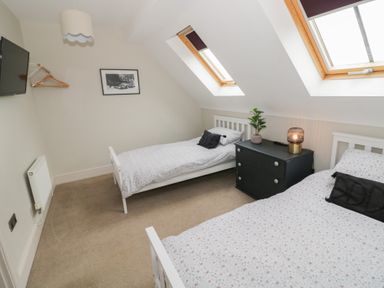 A bedroom with two single beds and a nightstand at Little Acre Church Lench near Harvington
