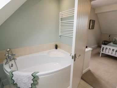 A bathroom with a bathtub and towel rack at Little Acre Church Lench near Harvington