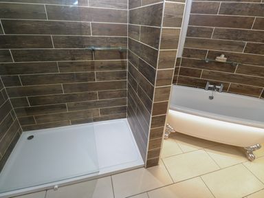 A bathroom with a walk-in shower and a clawfoot bathtub at Tremornah in Lamorna