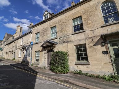 Stone buildings with windows and doors along a street with a traffic sign at Byfield House