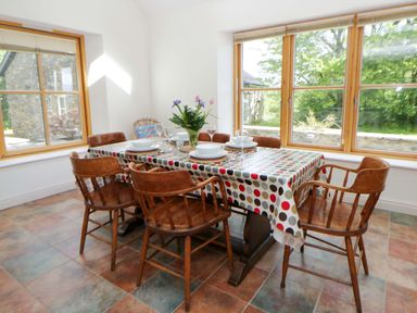 A dining room with a table and chairs at Bryn Isaf in Swyddffynnon near Pontrhydfendigaid