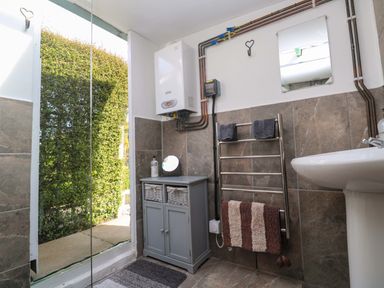 A bathroom with a shower and wash basin at Higher Merther Farm Shepherds Hut Helston