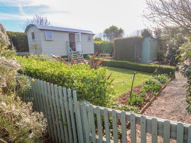 A shepherd hut in a garden area at Higher Merther Farm Shepherds Hut Helston