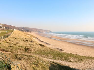 A beach with sand and ocean at Higher Merther Farm Shepherds Hut Sithney near Helston