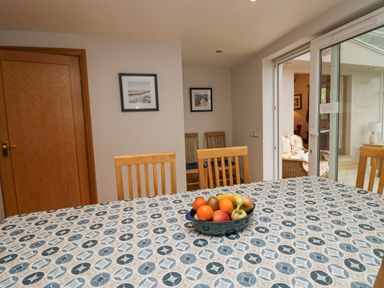 A dining room with a patterned tablecloth and a bowl of fruit on the table at Blue Hill House in Ambleside