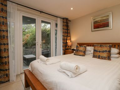 A bedroom with a bed with folded towels on it and a bedside table with a lamp at Blue Hill House in Ambleside