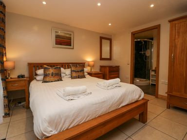 A bedroom with a wooden bed and two rolled towels on the bed at Blue Hill House in Ambleside
