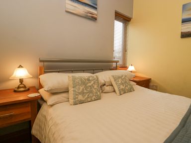 A bedroom with a bed and two bedside tables with lamps at Blue Hill House in Ambleside