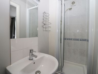 A bathroom with a sink and a shower enclosure with tiled walls at Park Beck 3 in Windermere